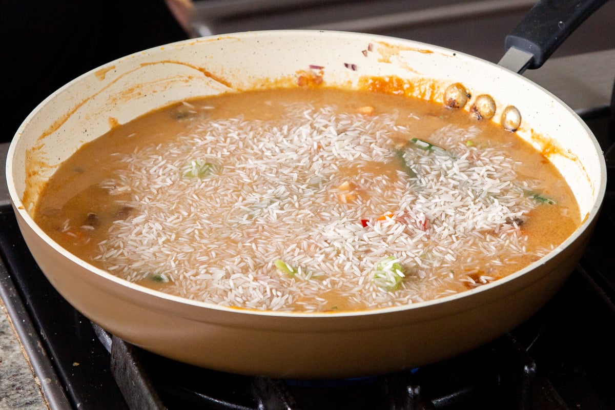 adding rice to the pan