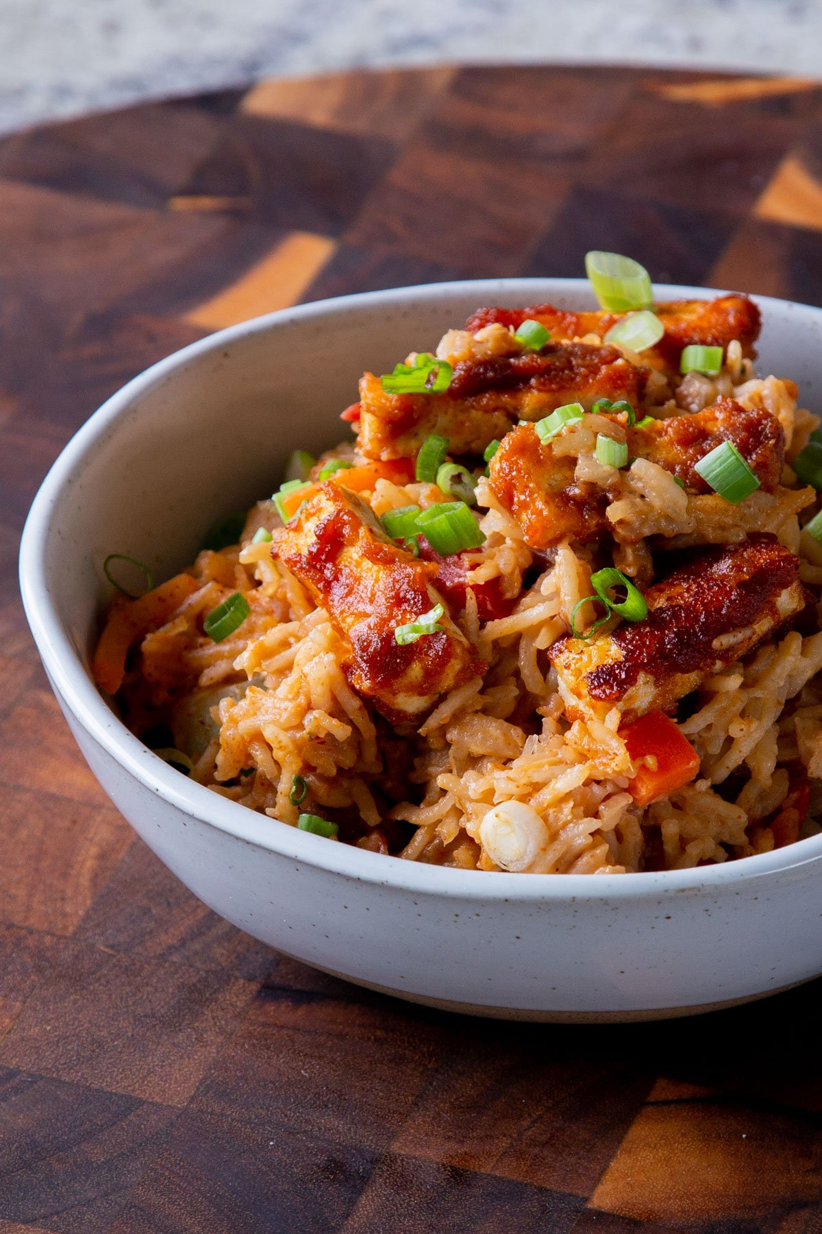 peanut gochujang rice topped with tofu and green onions in a bowl
