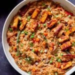peanut gochujang rice topped with tofu and green onions in a skillet