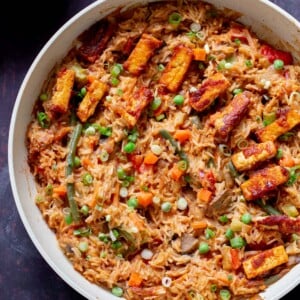 peanut gochujang rice topped with tofu and green onions in a skillet
