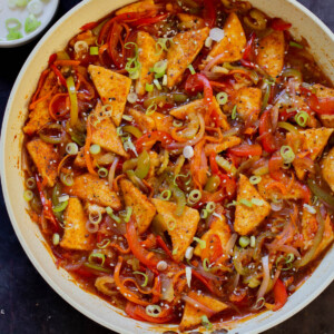 Szechuan tofu in the pan with green onions and sesame seeds