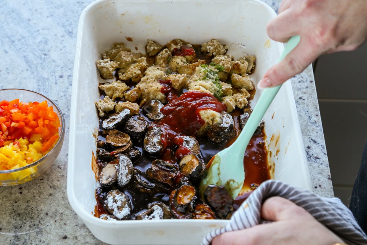 adding sauce ingredients to the pan of tofu and mushrooms