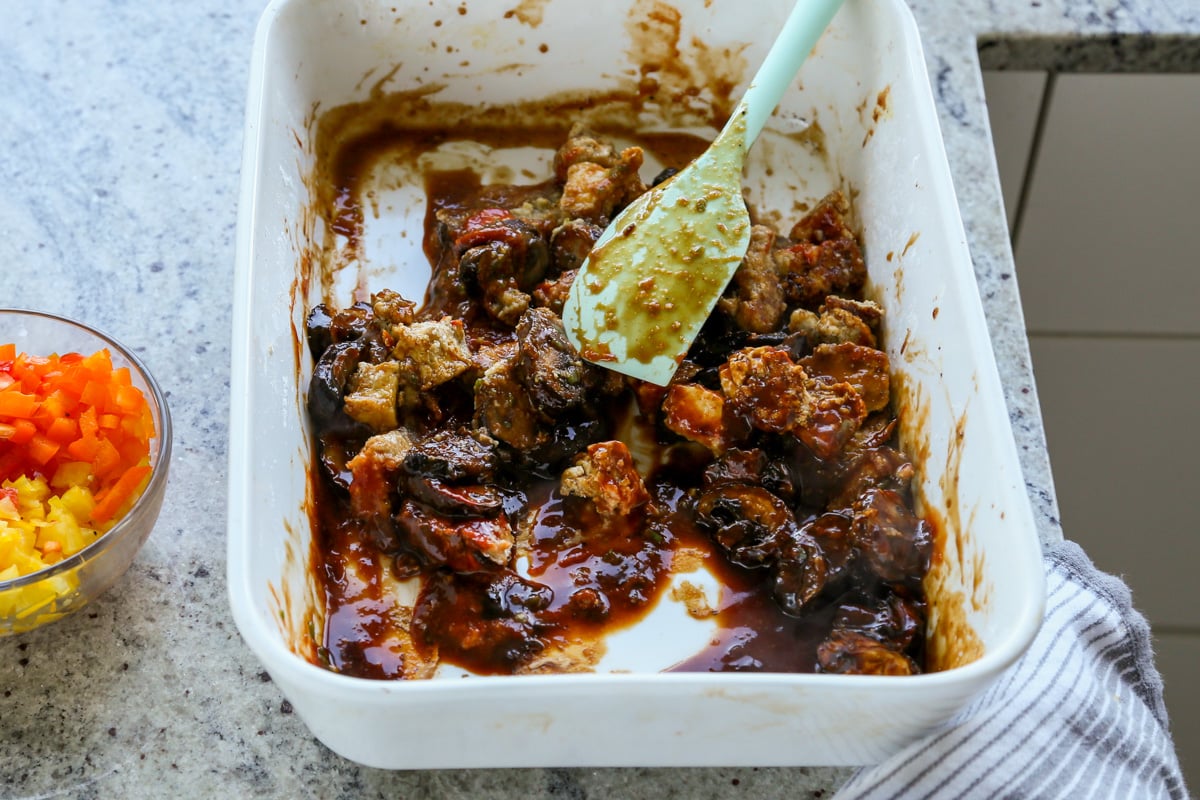 tossing tofu and mushrooms in the sauce