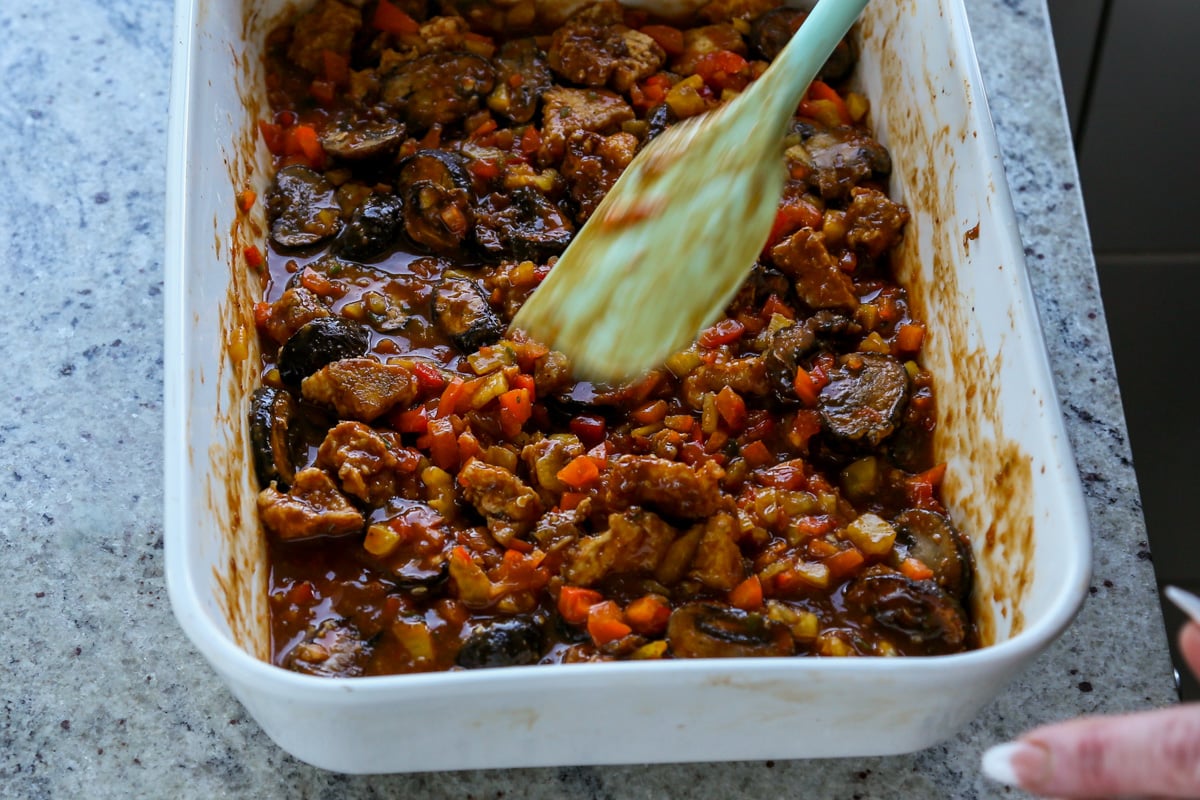 mushrooms, tofu, and peppers tossed in the sauce before baking