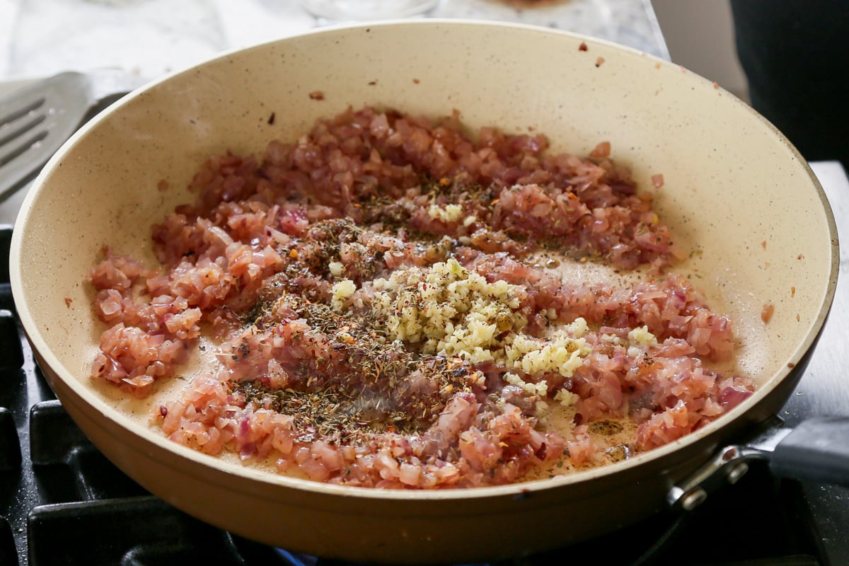 adding garlic and spices to the skillet