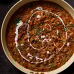 Dhaba chicken white beans in the pan topped with pepper flakes, cilantro, and non-dairy yogurt