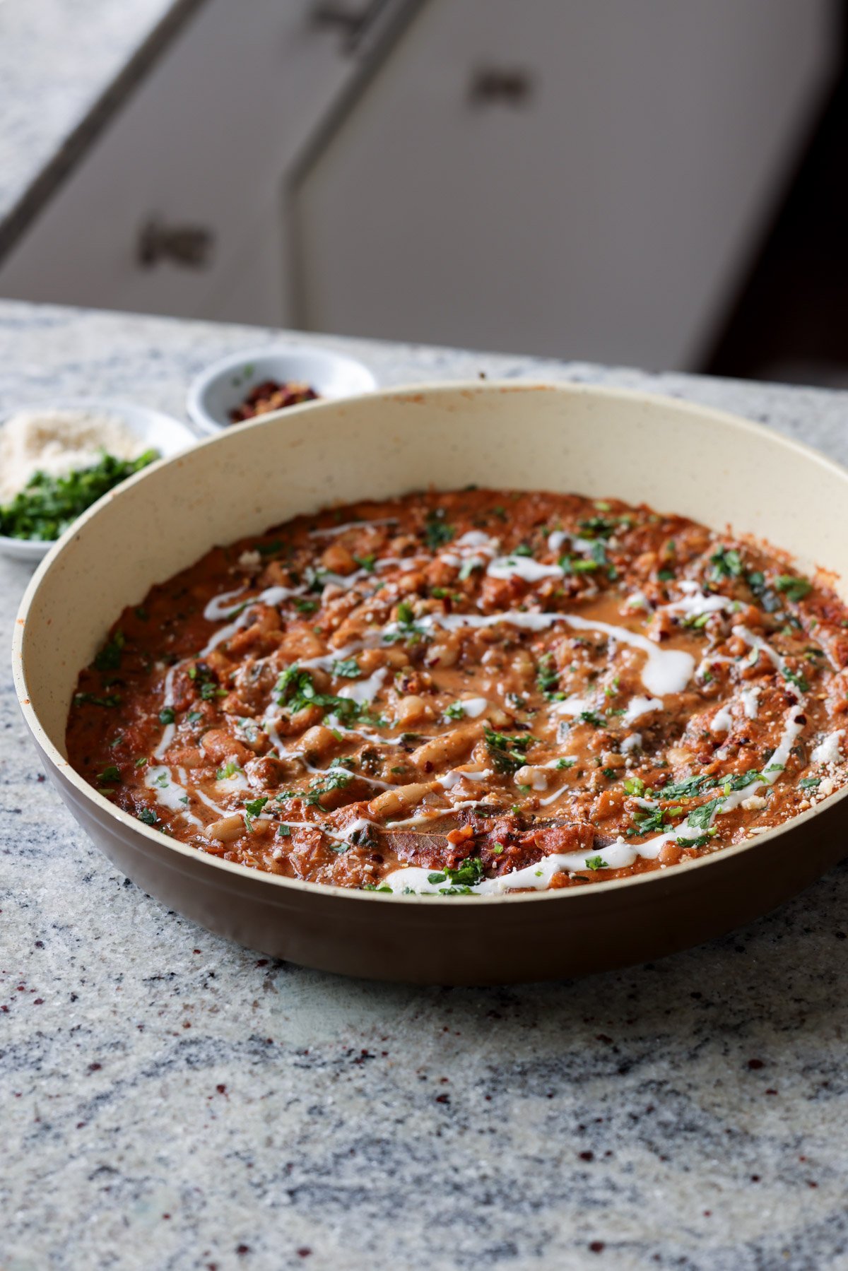 Dhaba chicken white beans in the pan topped with pepper flakes, cilantro, and non-dairy yogurt