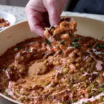 dipping sourdough into Dhaba chicken white beans