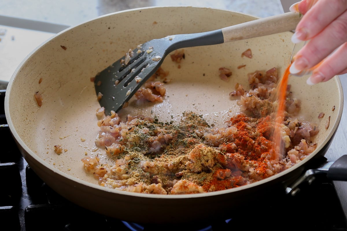 adding dried spices to the pan