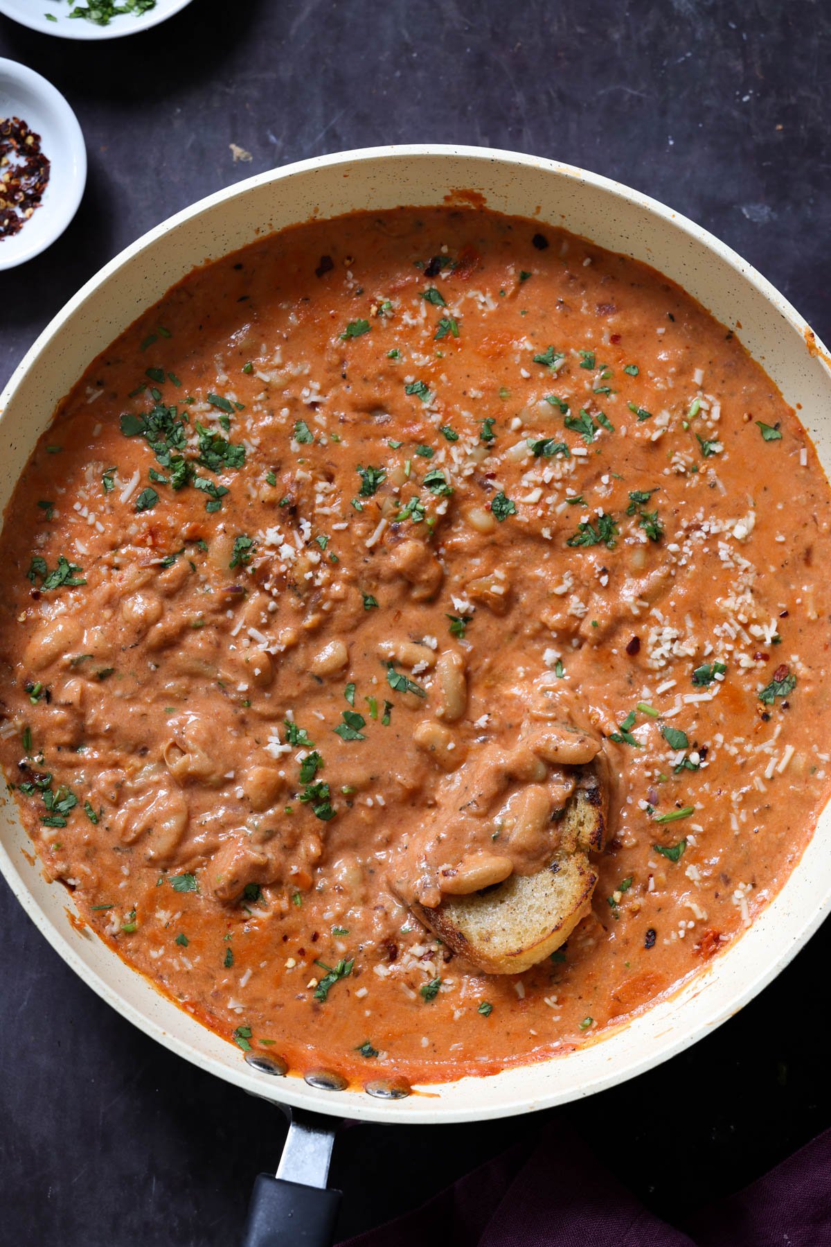 rosé sauce beans in the pan with sourdough dipped into it