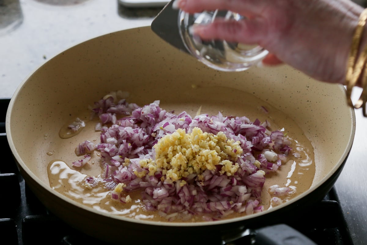 adding onion and garlic to the pan