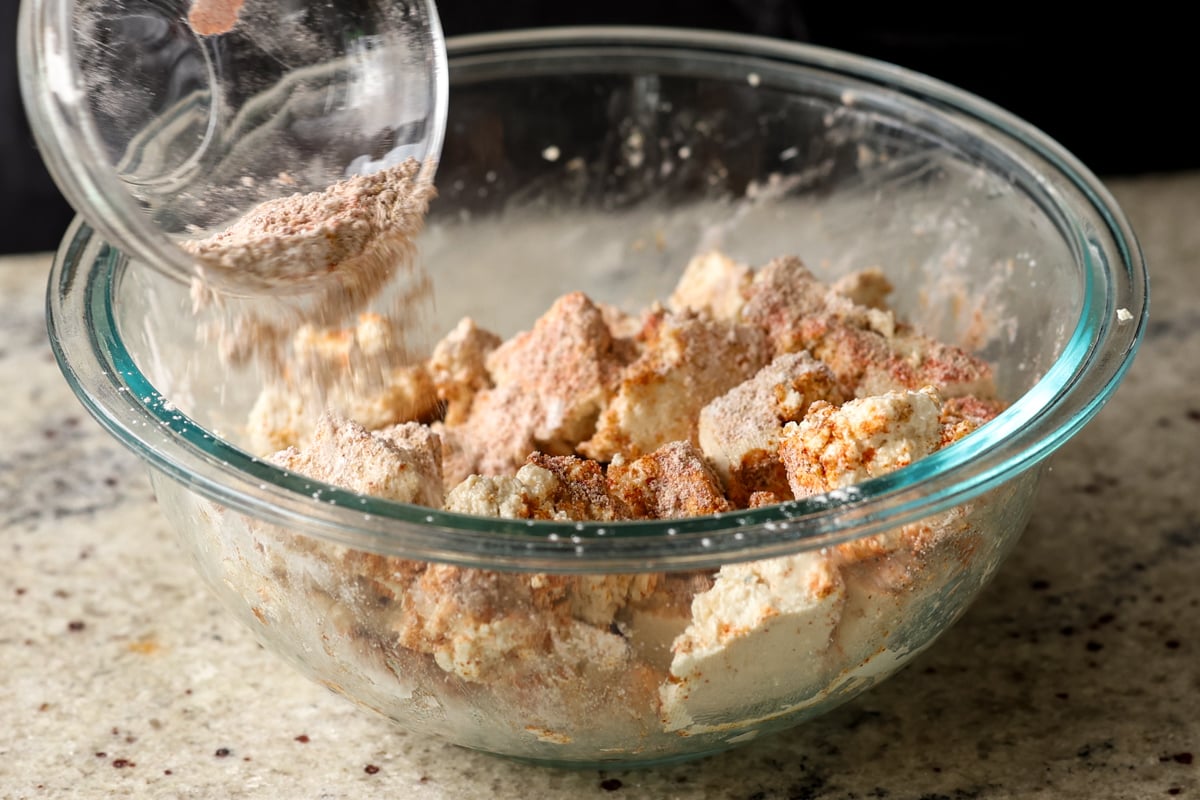 sprinkling cornstarch and spices over the tofu