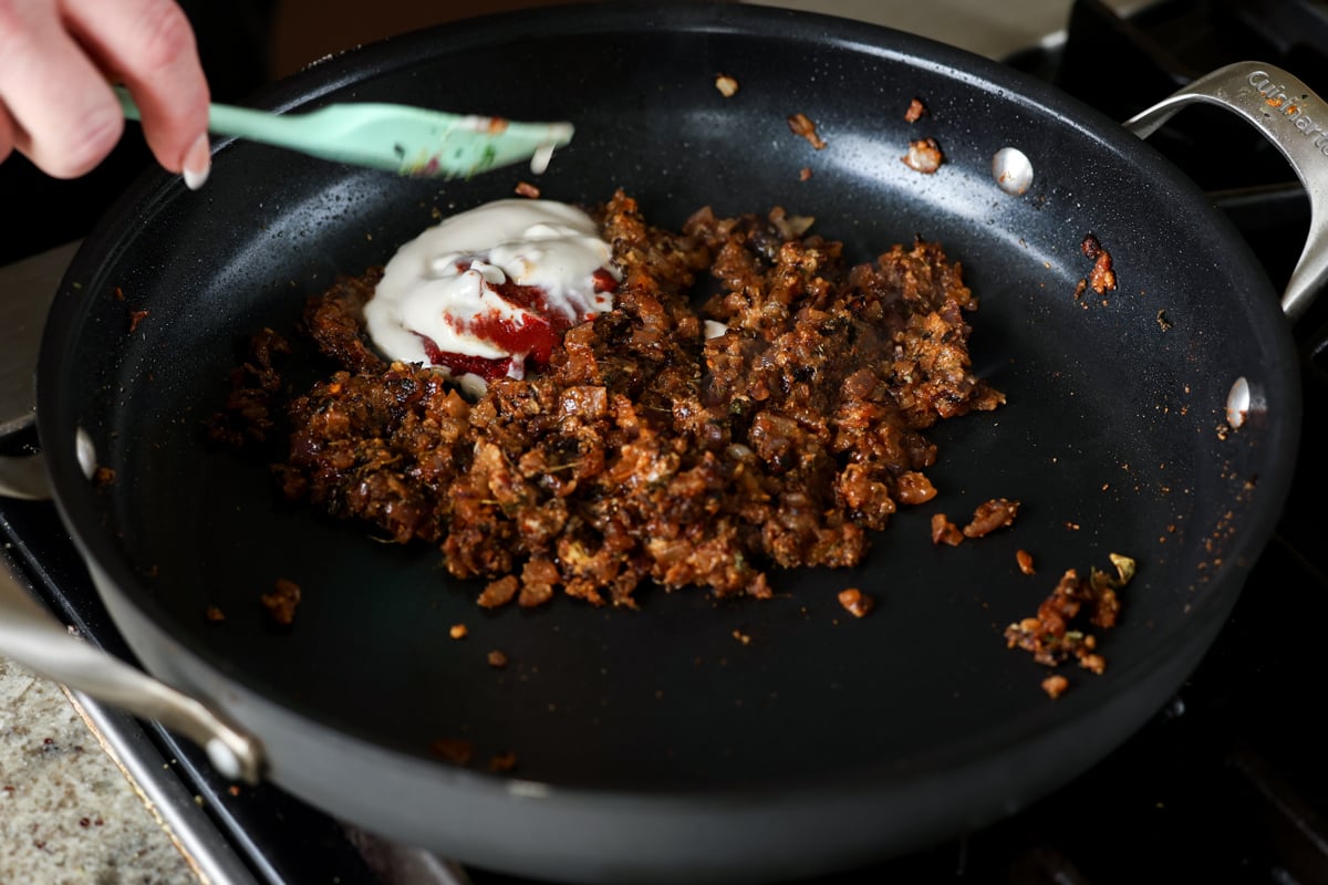 adding tomato paste and non-dairy yogurt to the pan