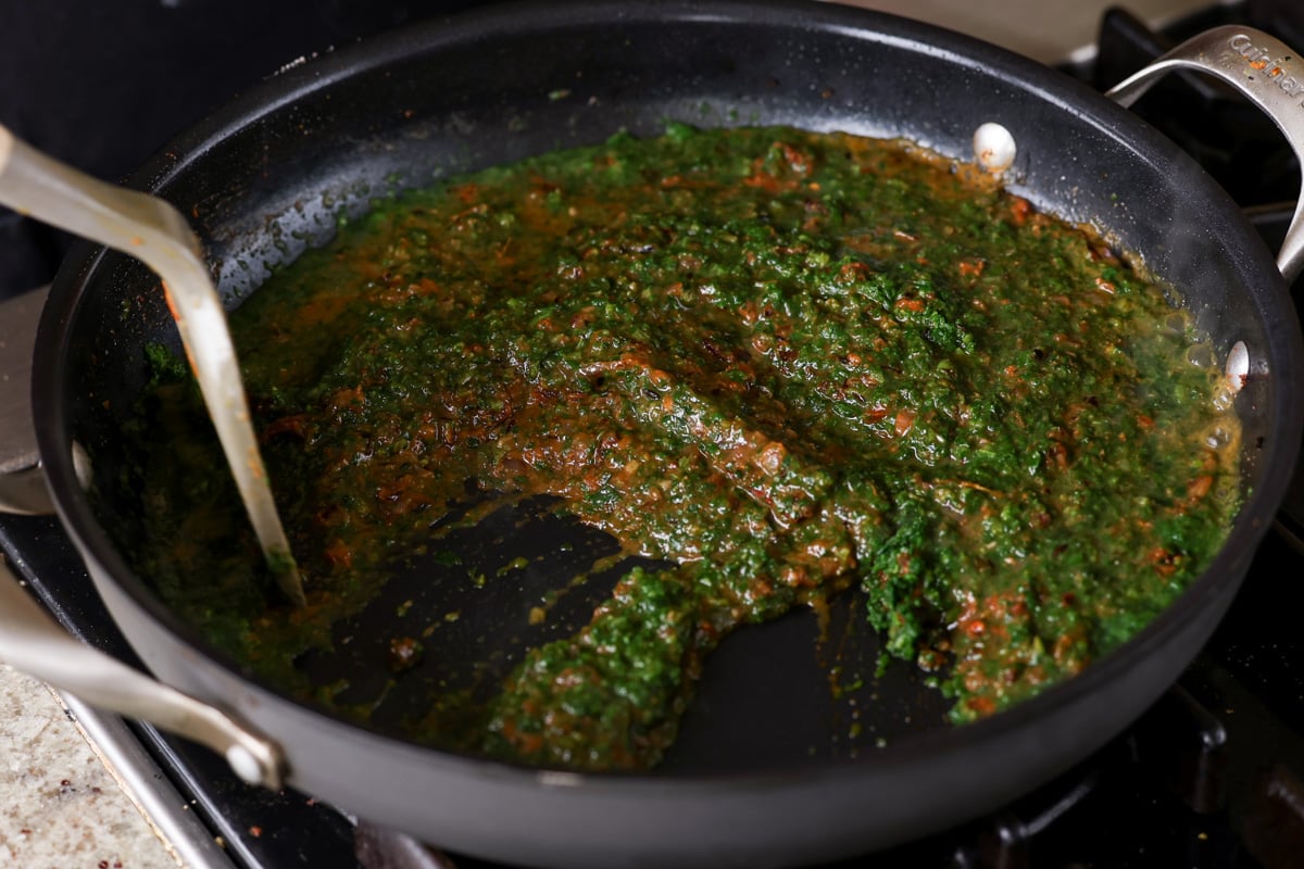 mixing spinach into the sauce