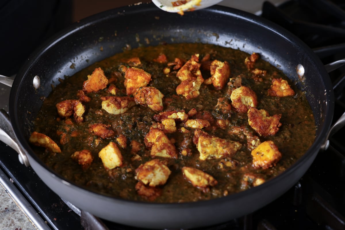 adding the crisped up tofu to the saagwala sauce