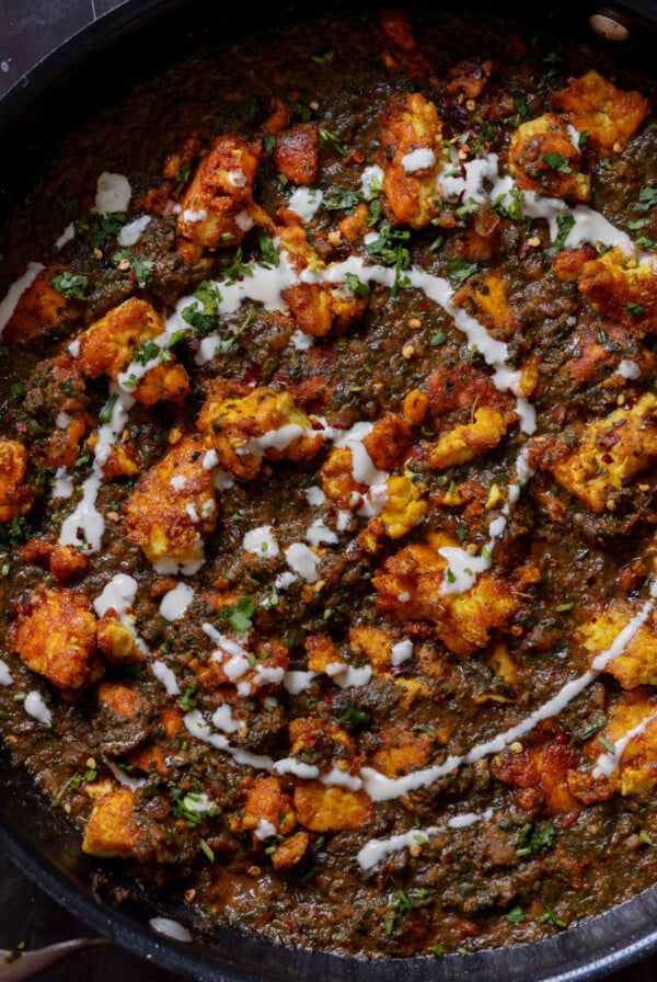 vegan chicken saagwala in the pan with all of the garnishes on top