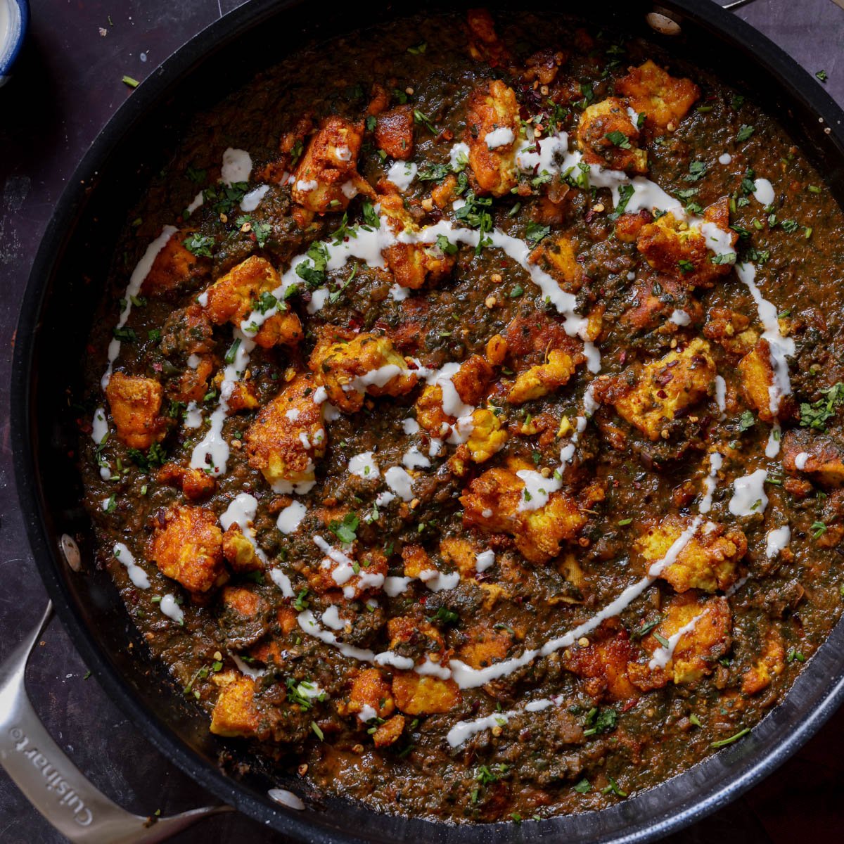 vegan chicken saagwala in the pan with all of the garnishes on top