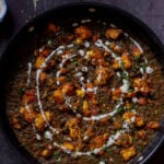 vegan chicken saagwala in the pan with all of the garnishes on top