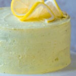 close-up of cake on the serving tray after frosting and topping with lemon slices