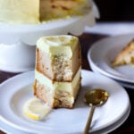 slice of vegan lemon cake on a plate with a bite taken out