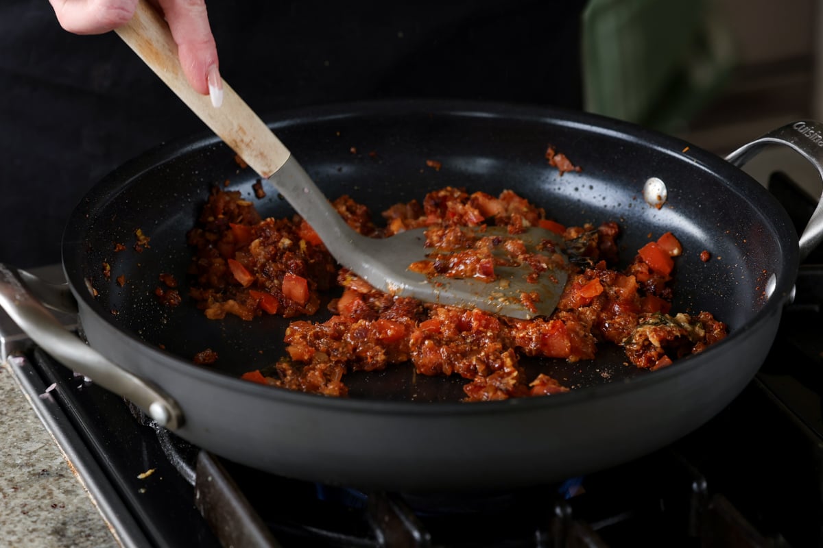 mashing the tomatoes after cooking