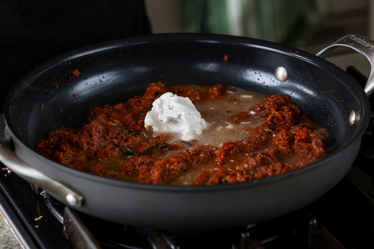 adding coconut milk to the pan