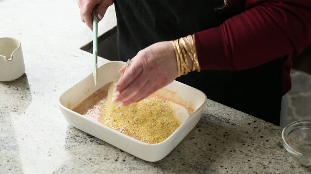adding flour, nutritional yeast, and spices to the cheese sauce
