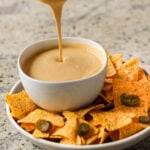pouring cashew nacho cheese into a serving bowl