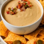 cashew nacho cheese in a serving bowl topped with salsa