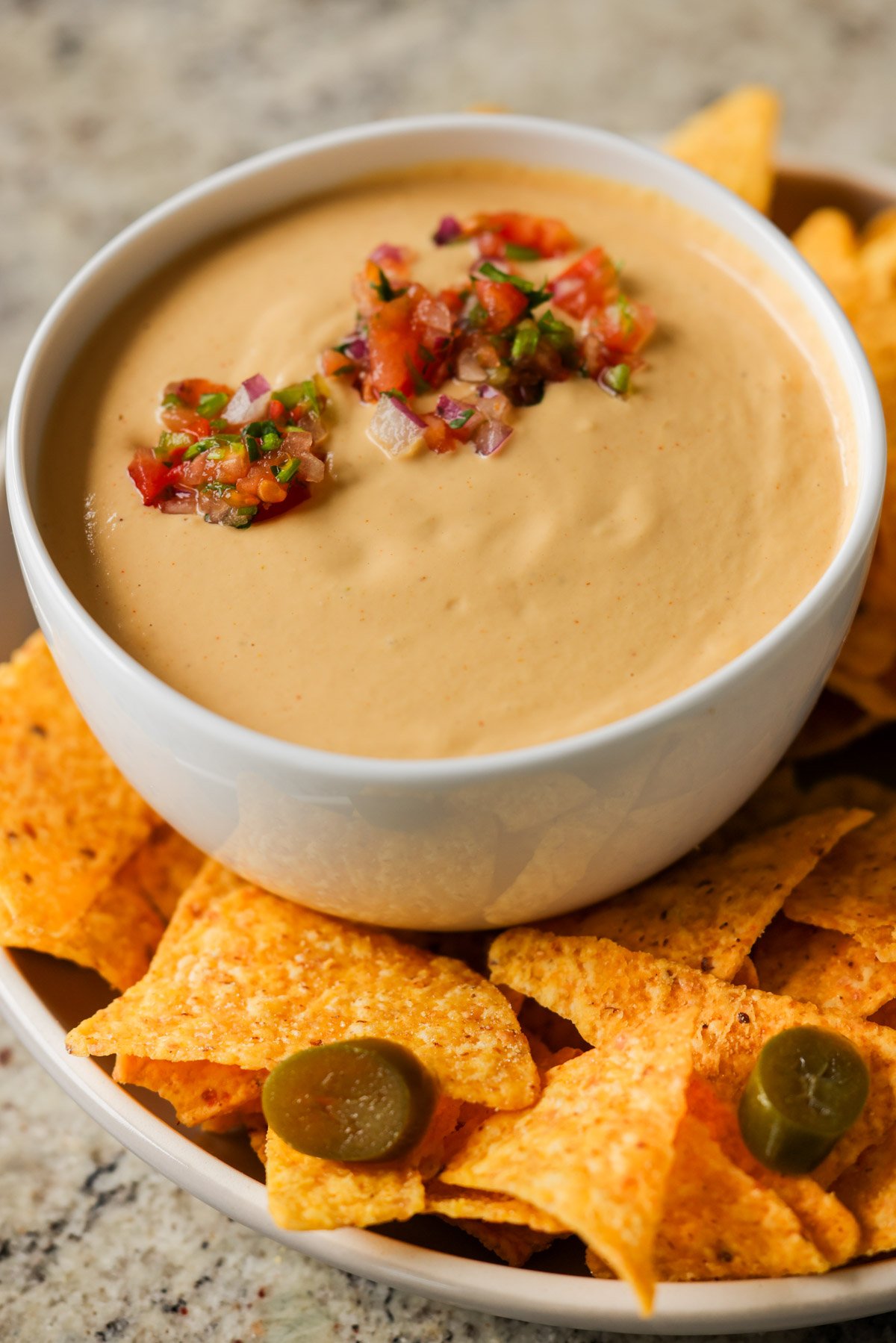 cashew nacho cheese in a serving bowl topped with salsa