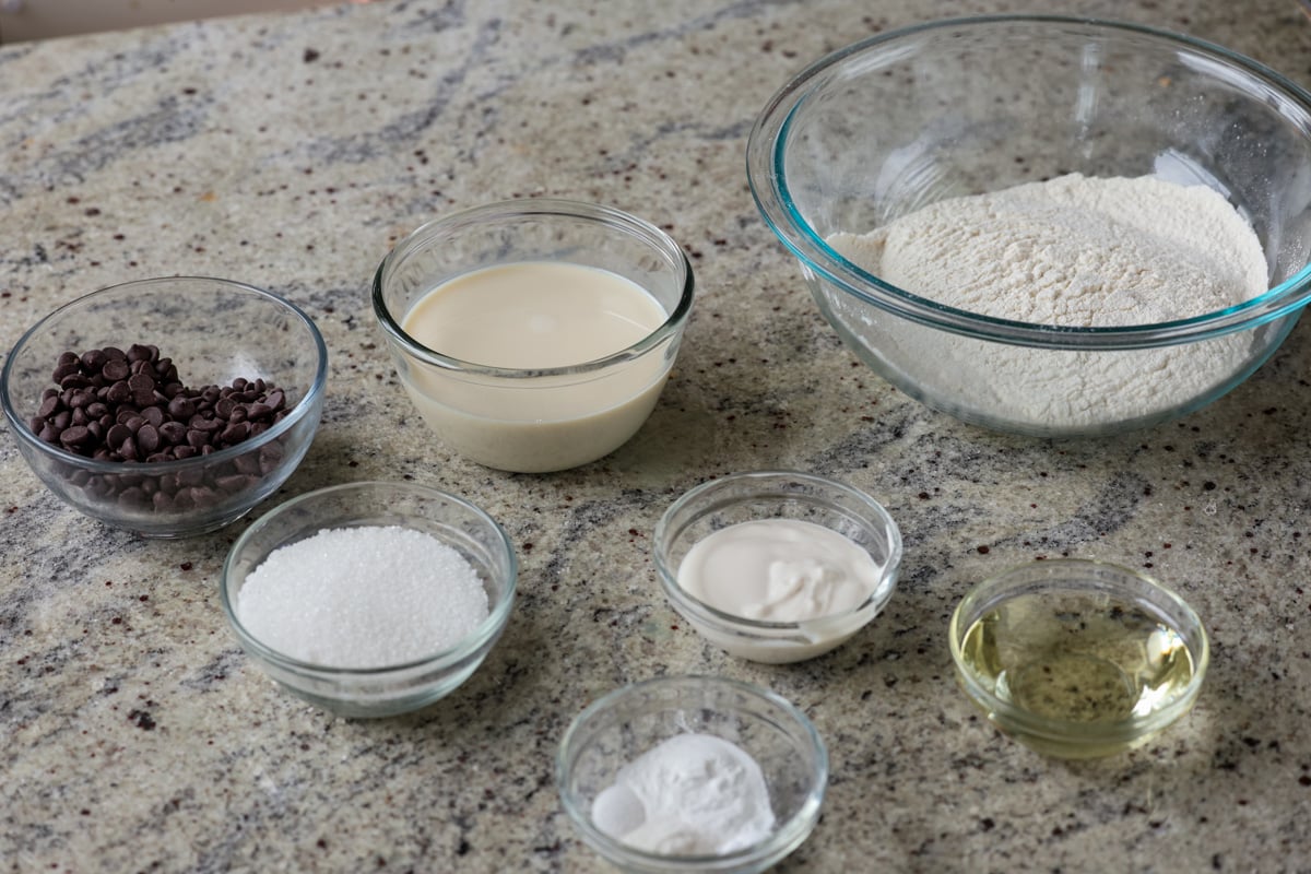 chocolate chip muffin ingredients in bowls on the kitchen counter