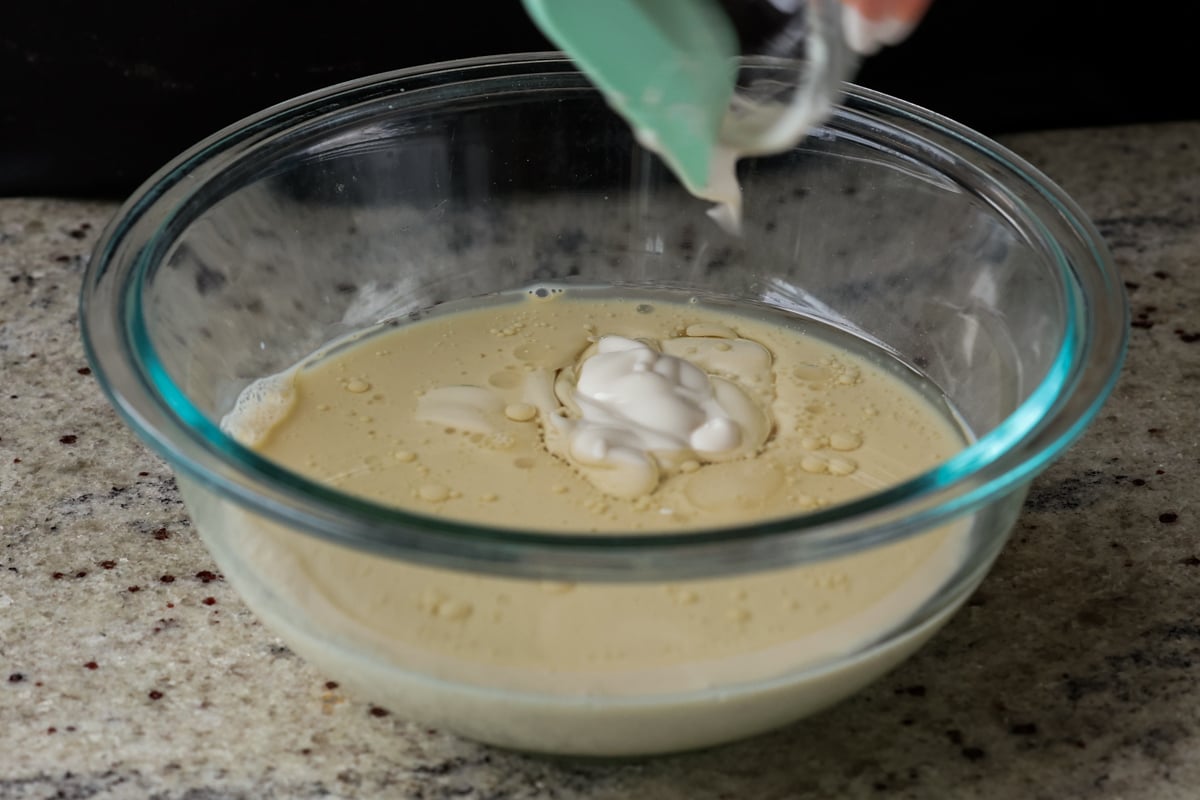 adding non-dairy yogurt to the bowl of wet ingredients
