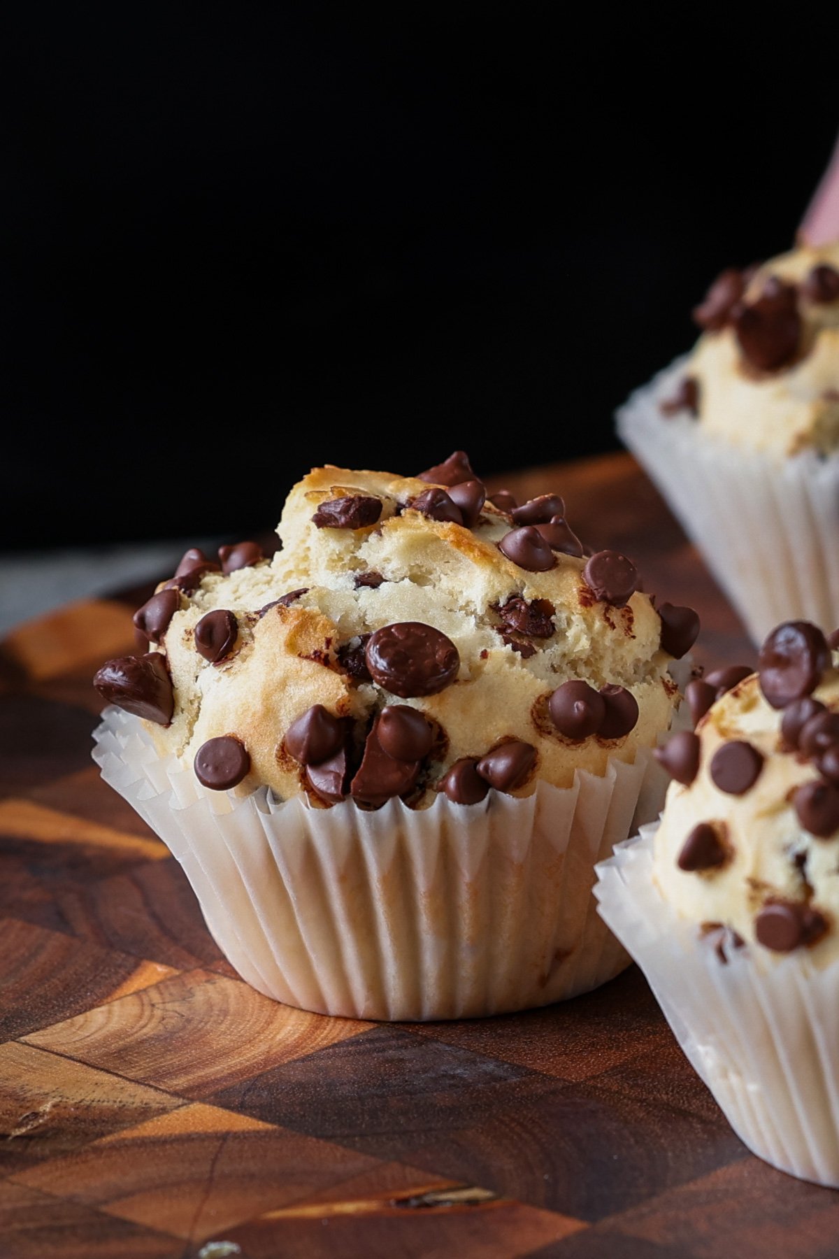 chocolate chip muffin on a wooden cutting board