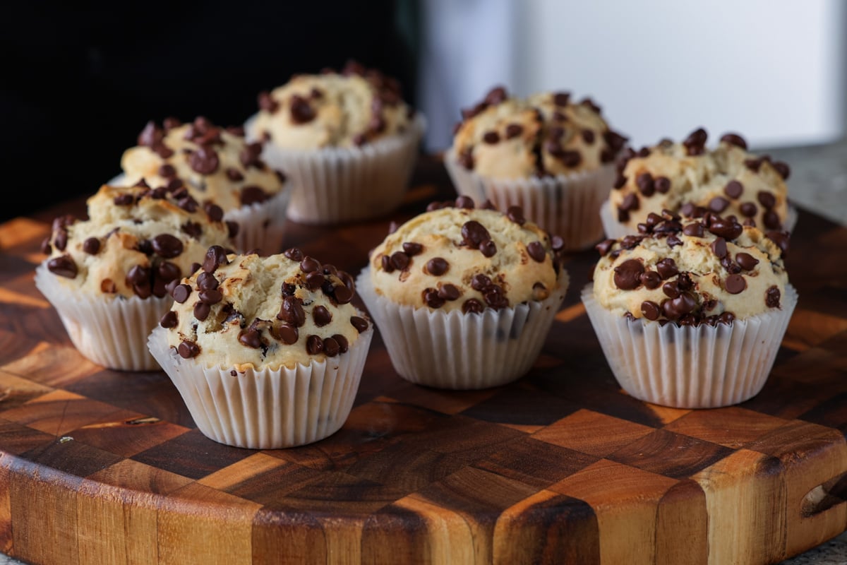 lots of chocolate chip muffins on a wooden cutting board