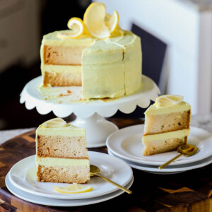 vegan lemon cake on the cake stand next to slices of the cake