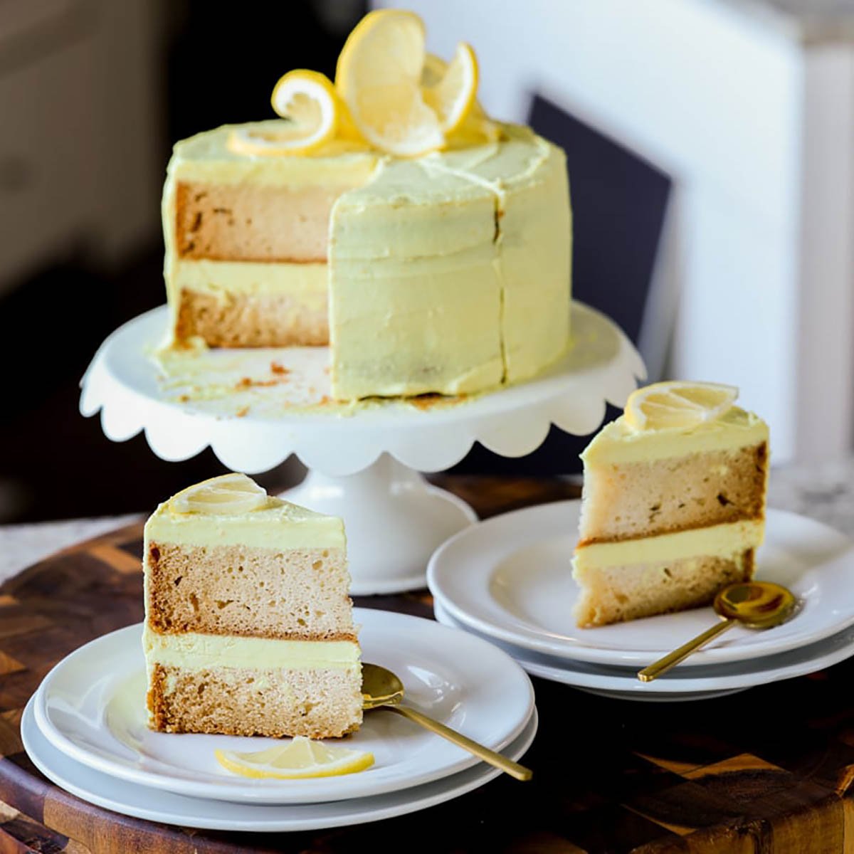 vegan lemon cake on the cake stand next to slices of the cake