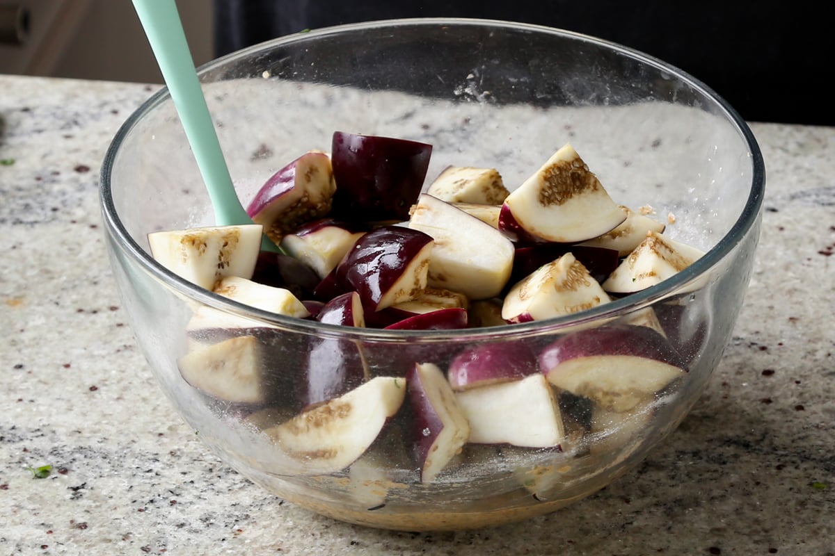 adding eggplant to the batter in the bowl