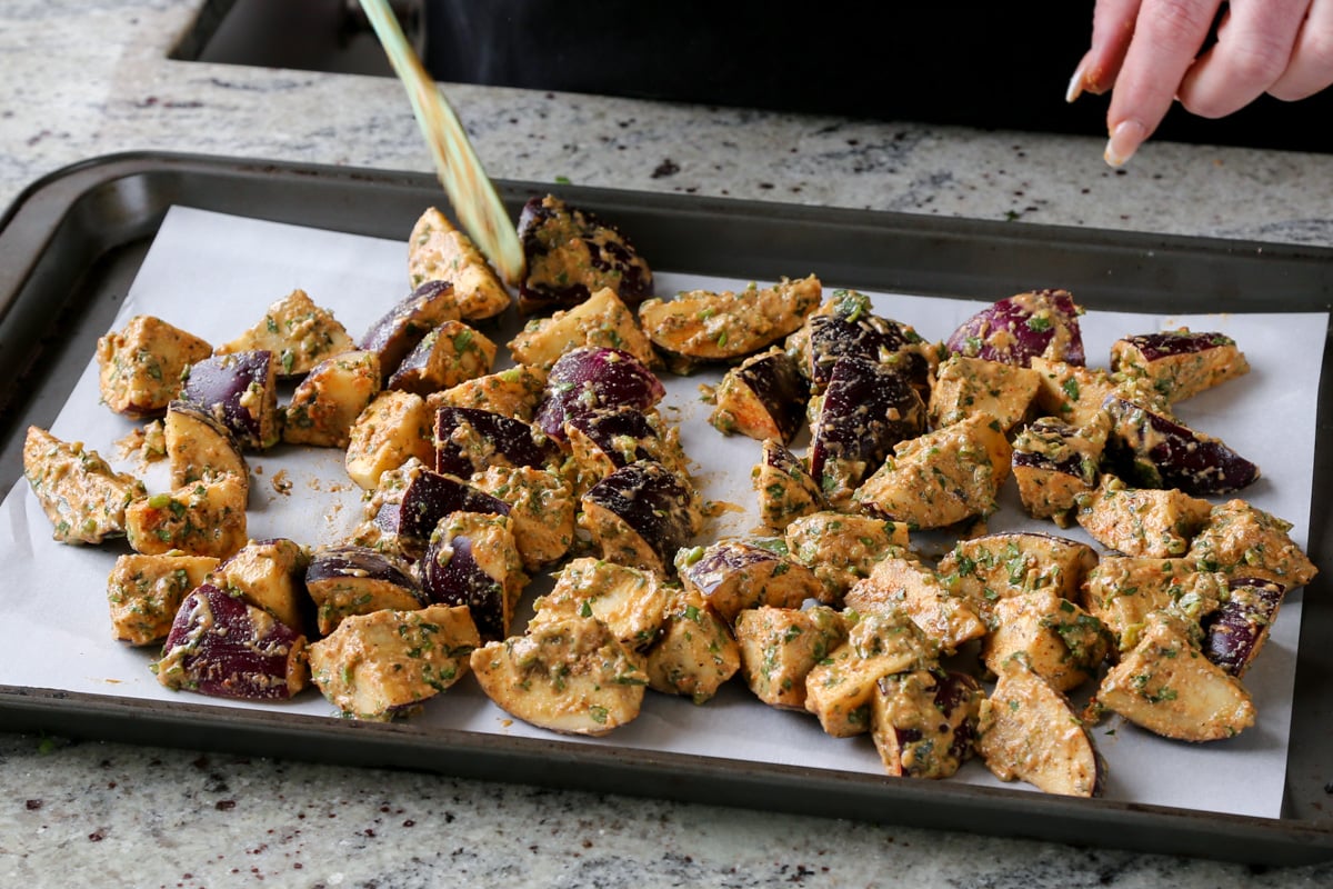 spreading battered eggplant onto a baking sheet
