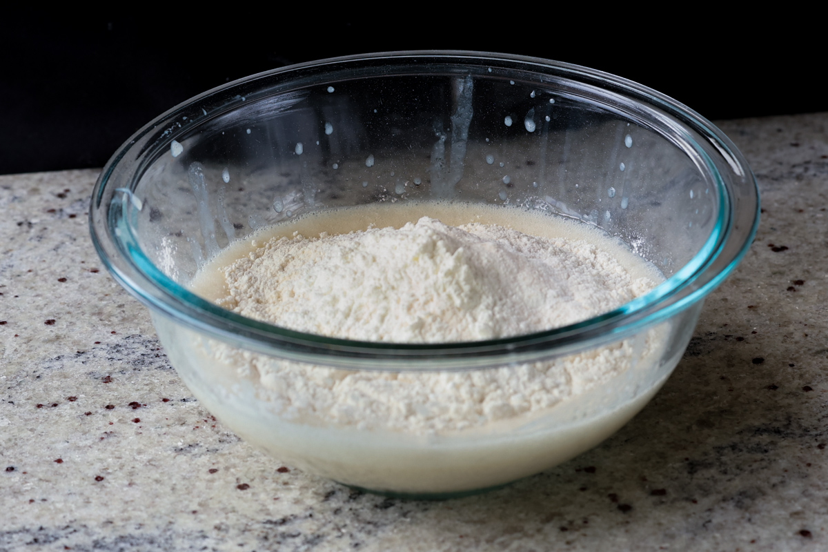 adding dry ingredients to the wet ingredients in a bowl