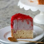 slice of strawberry mousse cake on a plate with a spoon