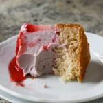 strawberry mousse cake slice on a plate with a bite taken out