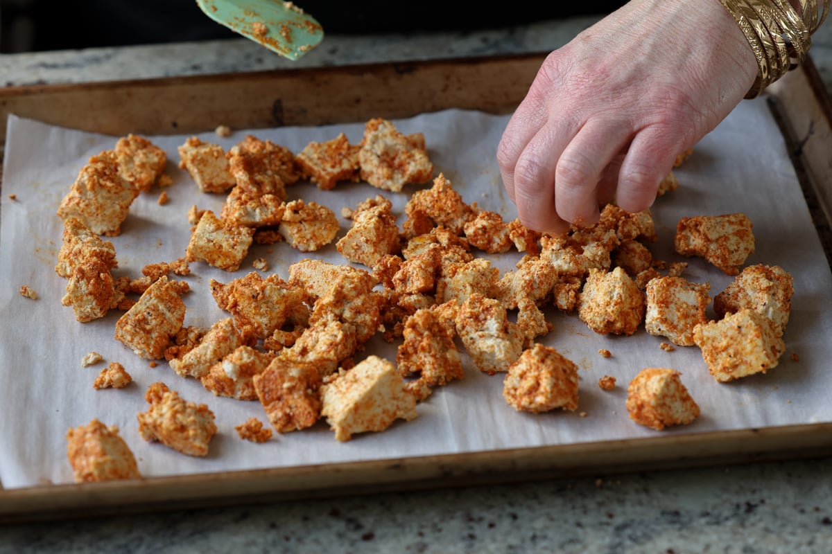 spreading tofu onto the baking sheet