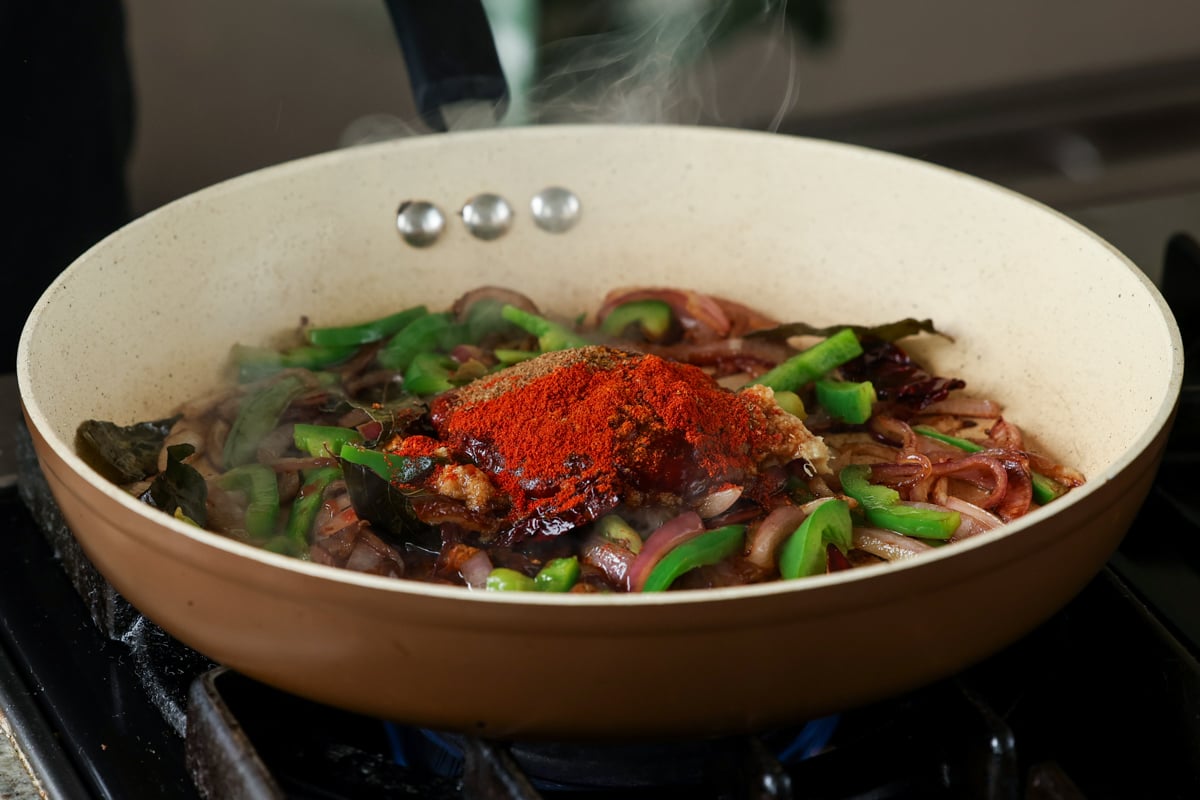 adding dried spices to the pan