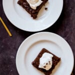 almond butter brownies on plates topped with vegan ice cream
