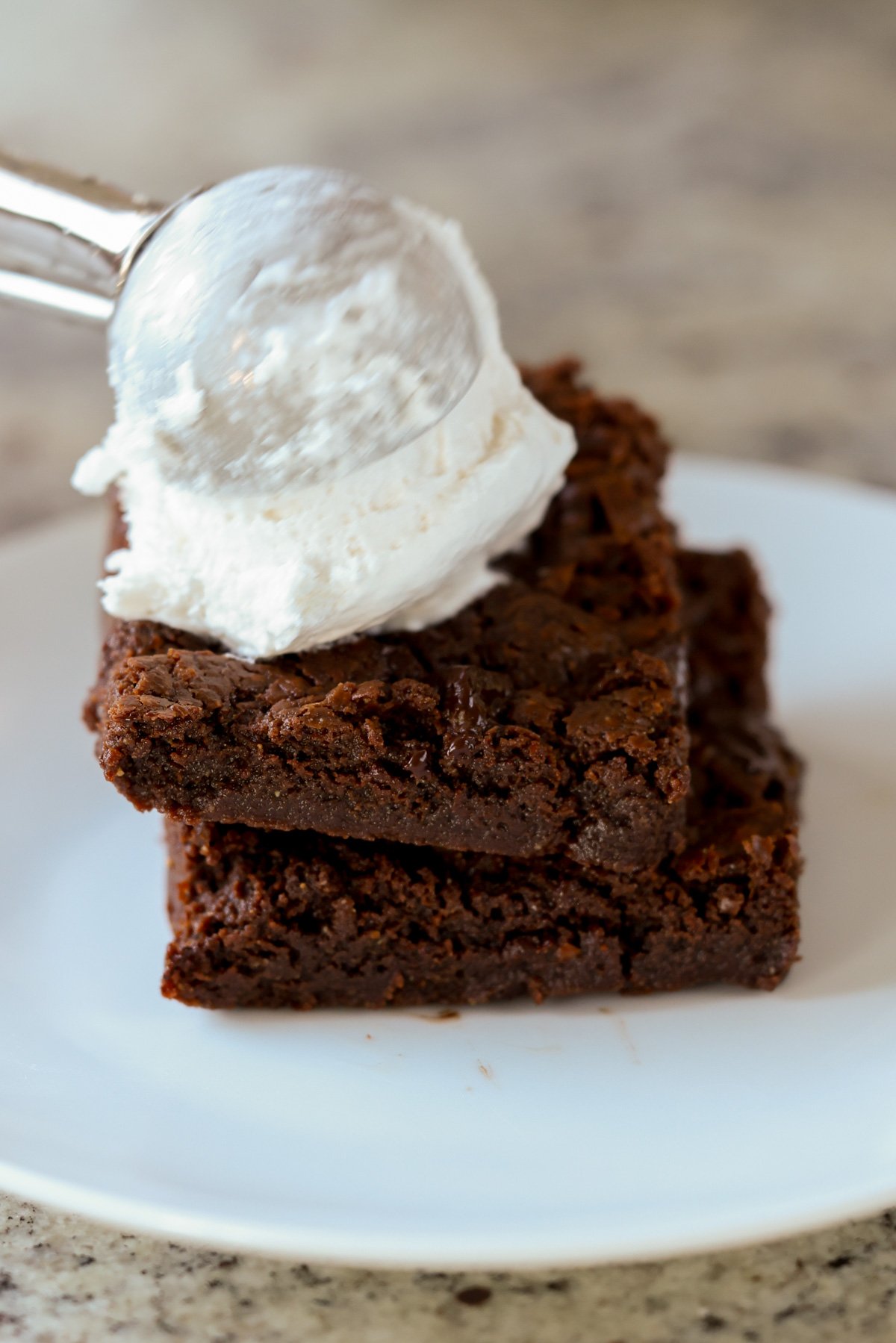 scooping ice cream onto the brownies