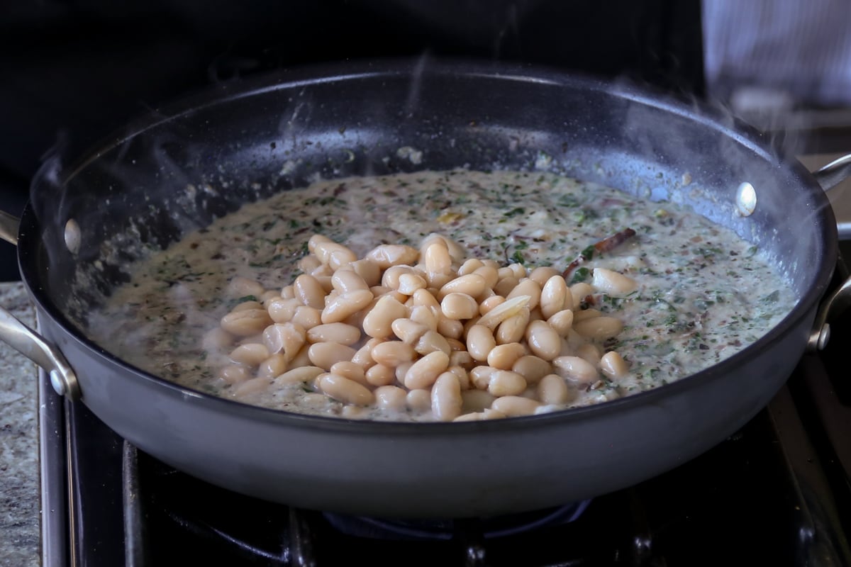 adding beans to the kali mirch sauce in the pan