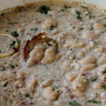 lemon garlic butter beans in a pan with a piece of bread