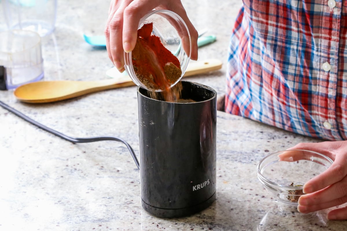 pouring spices into a spice grinder
