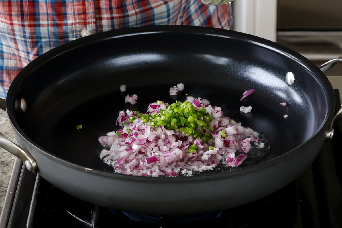 onion and green chili in the pan before cooking