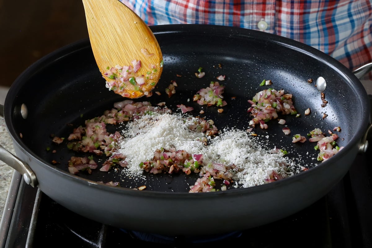 adding coconut to the mixture in the pan
